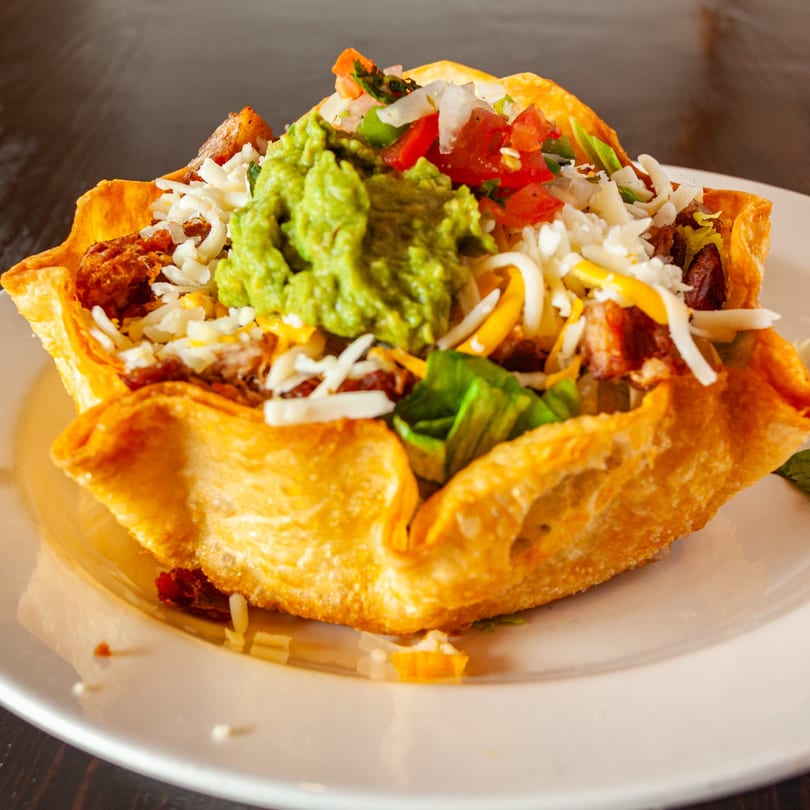 La Fogata Mexican Restaurant's taco salad in a crispy fried tortilla bowl with guacamole, cheese, and pico de gallo.