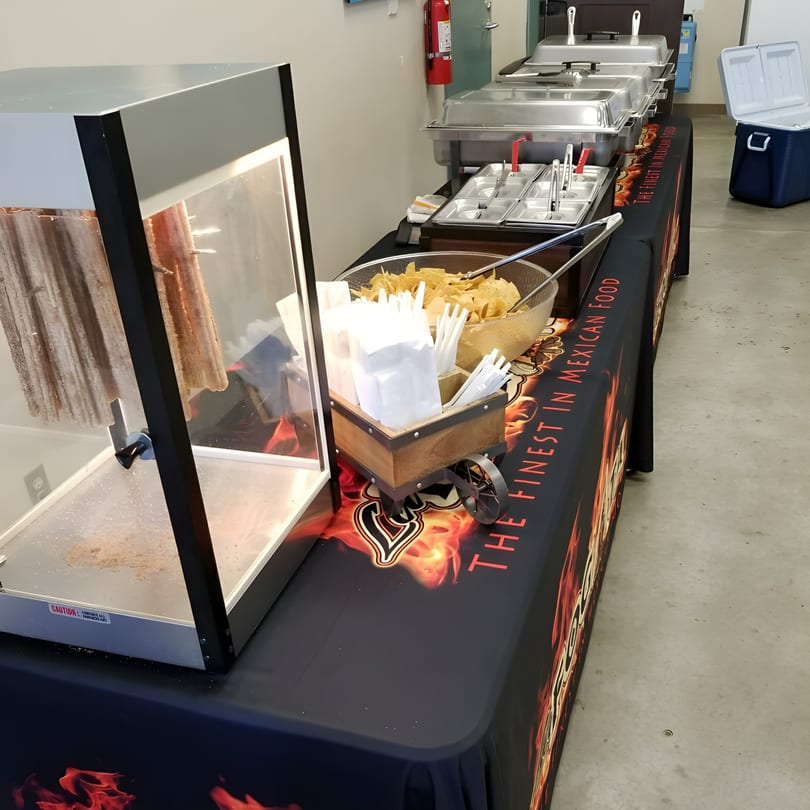 A La Fogata Mexican Restaurant catering setup with food warmers, chips, and a churro machine.
